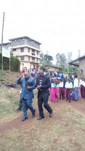 Graduation ceremony with former Bishop, in the background the school with new floor